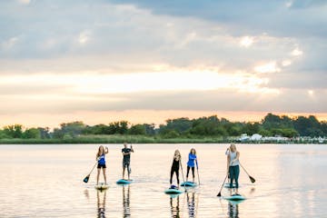 Group of people doing stand up paddle board tour