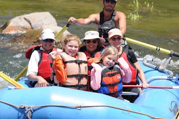 group of children and family smiling in raft