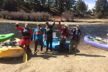 group standing on land with rafts smiling
