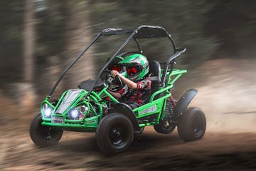 A kid drives a green off-road go-kart on a course at Purgatory Ski Resort