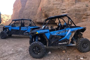 a blue RZR is parked on the sand near pinnacles in California's desert
