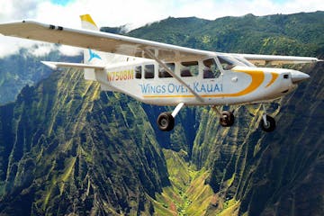 Wings Over Kauai's AirVan tour plane flying over Honopu