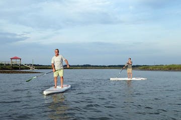 2 people on stand up paddle boards in the water