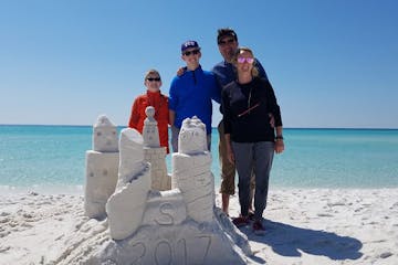 family of four creating sand sculptures