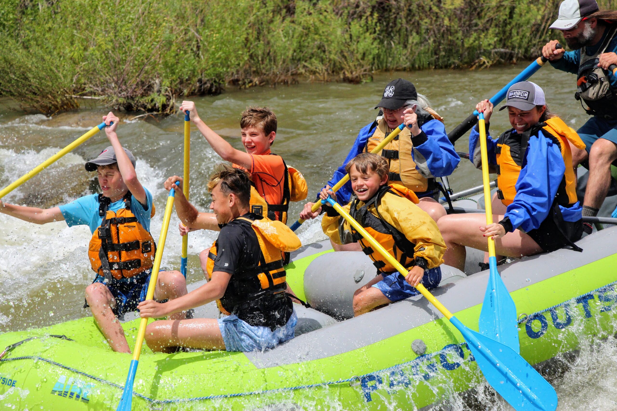 a group of people on a raft laughing on the river in Pagosa Springs