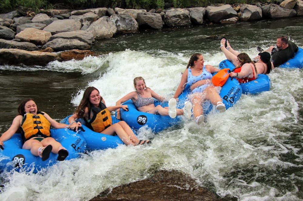 a group of tubers in a line floating through a rapid