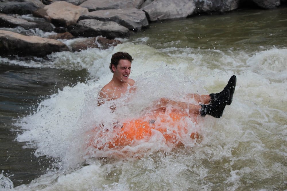 a young man riding a wave on a river tube