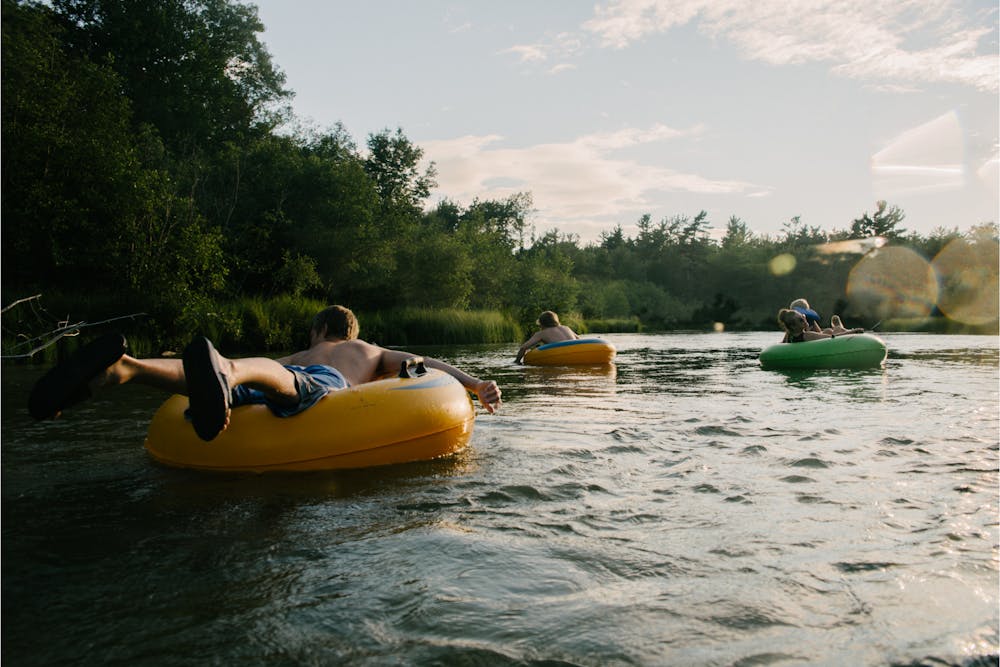 3 river tubers float down a river in colorado