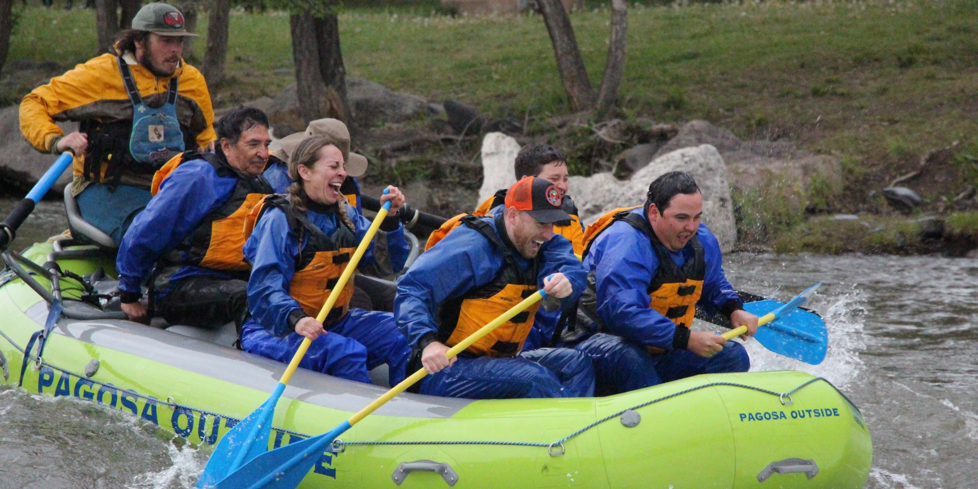 a group of people on a green raft on the river