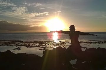 Jonathan doing a yoga pose on the beach at sunrise
