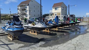 jetskis in parking lot waiting for service work
