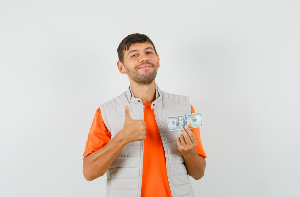 A man holding a hundred dollar bill