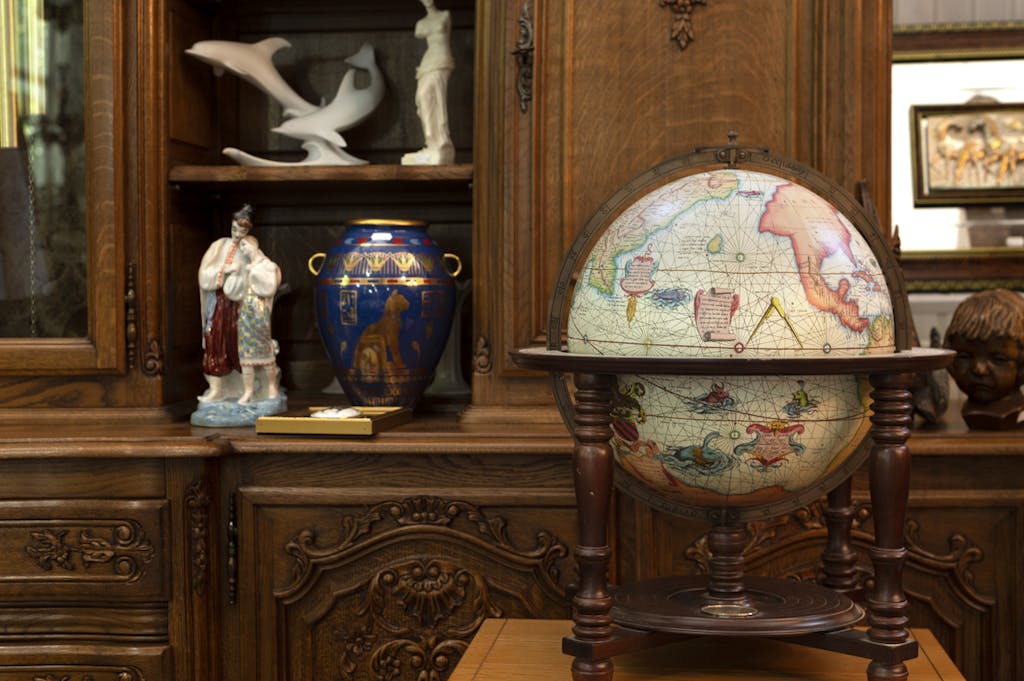 A globe and some arts displayed in a museum