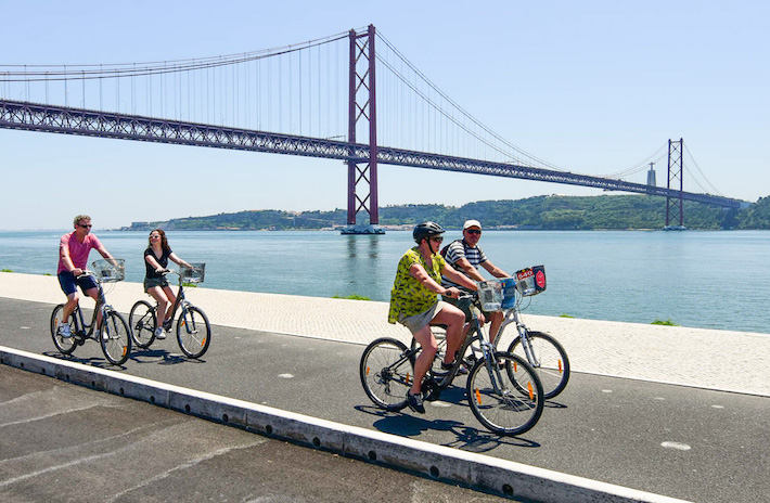 a person riding a bicycle on a bridge over a body of water