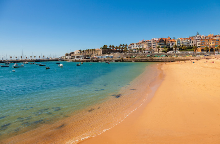 a sandy beach next to a body of water