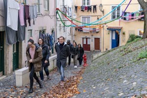 a group of people walking down the old streets in Lisbon