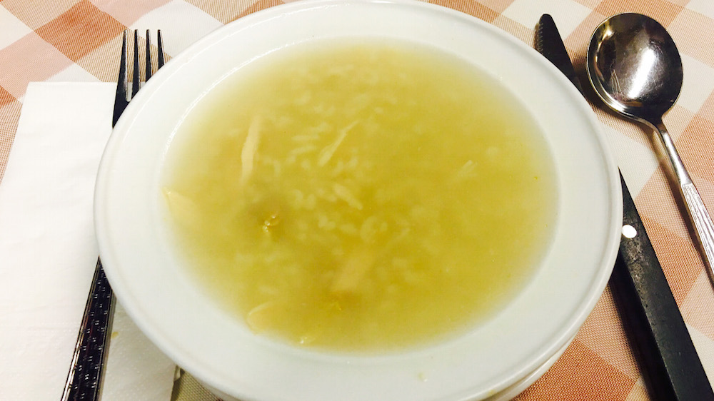 a bowl of soup and a spoon on a table