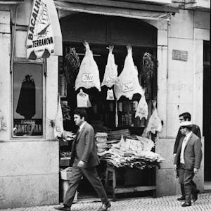 a group of people standing in front of a codfish store in Lisbon