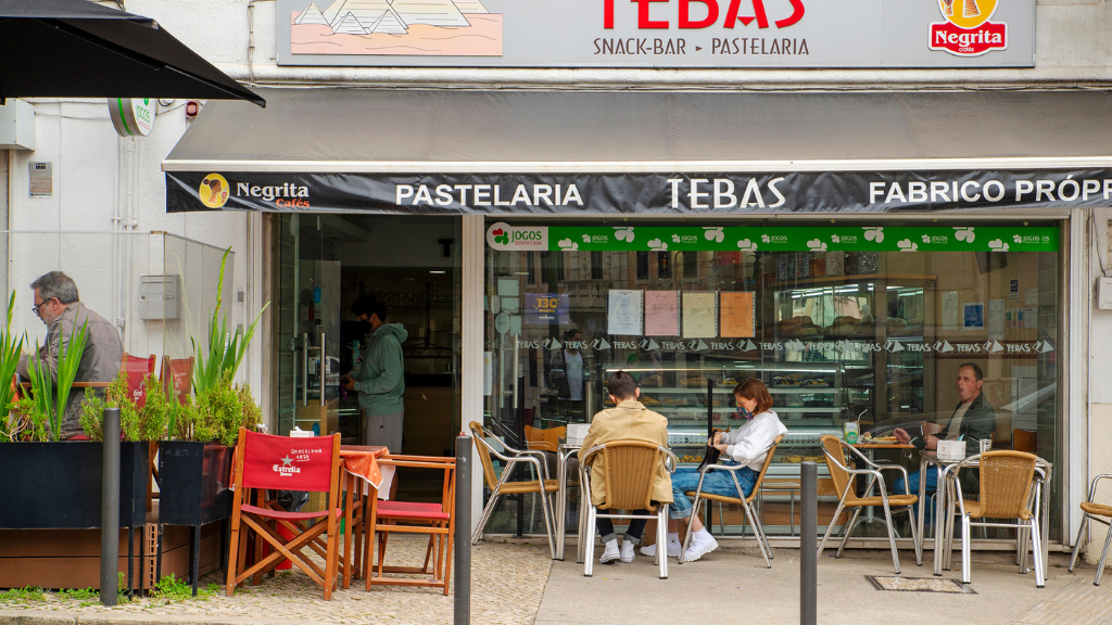 a group of people sitting at a table in front of a store