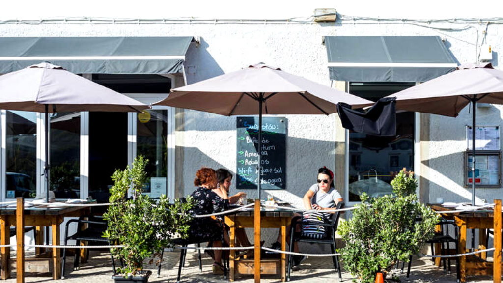 a person sitting at a table with an umbrella