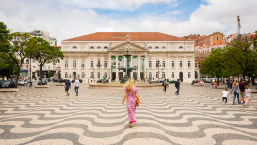 a little girl standing in front of a building