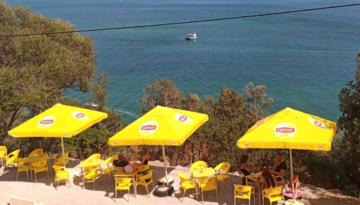 a group of people sitting at a beach umbrella in the water