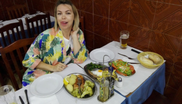 a woman sitting at a table with a plate of food