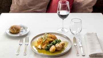 a plate of food and glasses of wine on a table