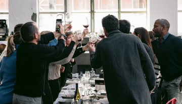 a group of people are drinking from a wine glass