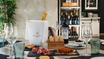 champagne, wine, croquettes, ham, olives, basket with bread, glasses on a table