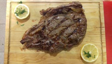 a steak sitting on top of a wooden cutting board