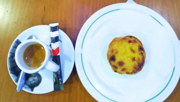 A Coffee and a plate with a custard tart