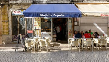tables and chairs in front of A Ginjunha Popular