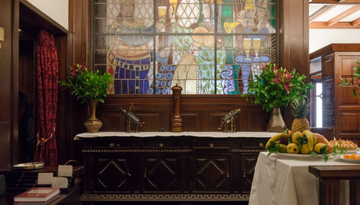 a room filled with furniture and vase of flowers on a table