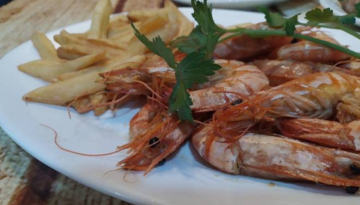a plate of food with prawns and french fries