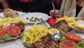 a person sitting at a table with a plate of food