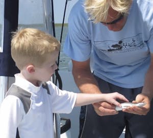 Child touching a fish