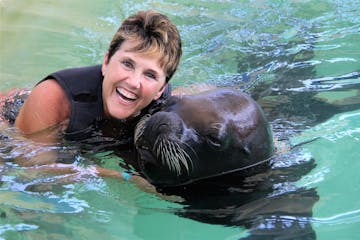 A woman poses with a sea lion at Coral World Ocean Park