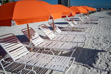 a group of lawn chairs sitting on top of a beach