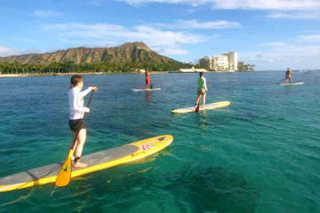 group stand up paddleboarding in water