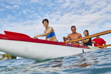 people rowing in kayak smiling on water