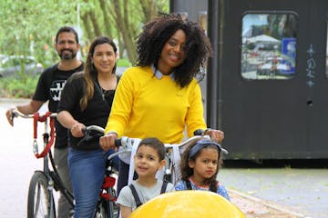 Debora on a clog bike with two kids