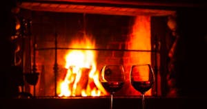 a fire place and a glass of wine