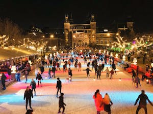 a group of people ice skating surrounded by a crowd