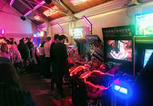 a group of people standing in a room with arcade games