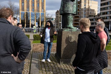 a hairy stand-up comedian standing in front of a group during a Comedy Walk Eindhoven