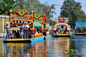 a group of people riding on the back of a boat with Xochimilco in the background