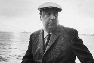 Pablo Neruda wearing a suit and hat