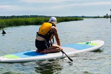woman sitting on a paddle board in the river