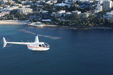 a plane flying over a body of water with a city in the background
